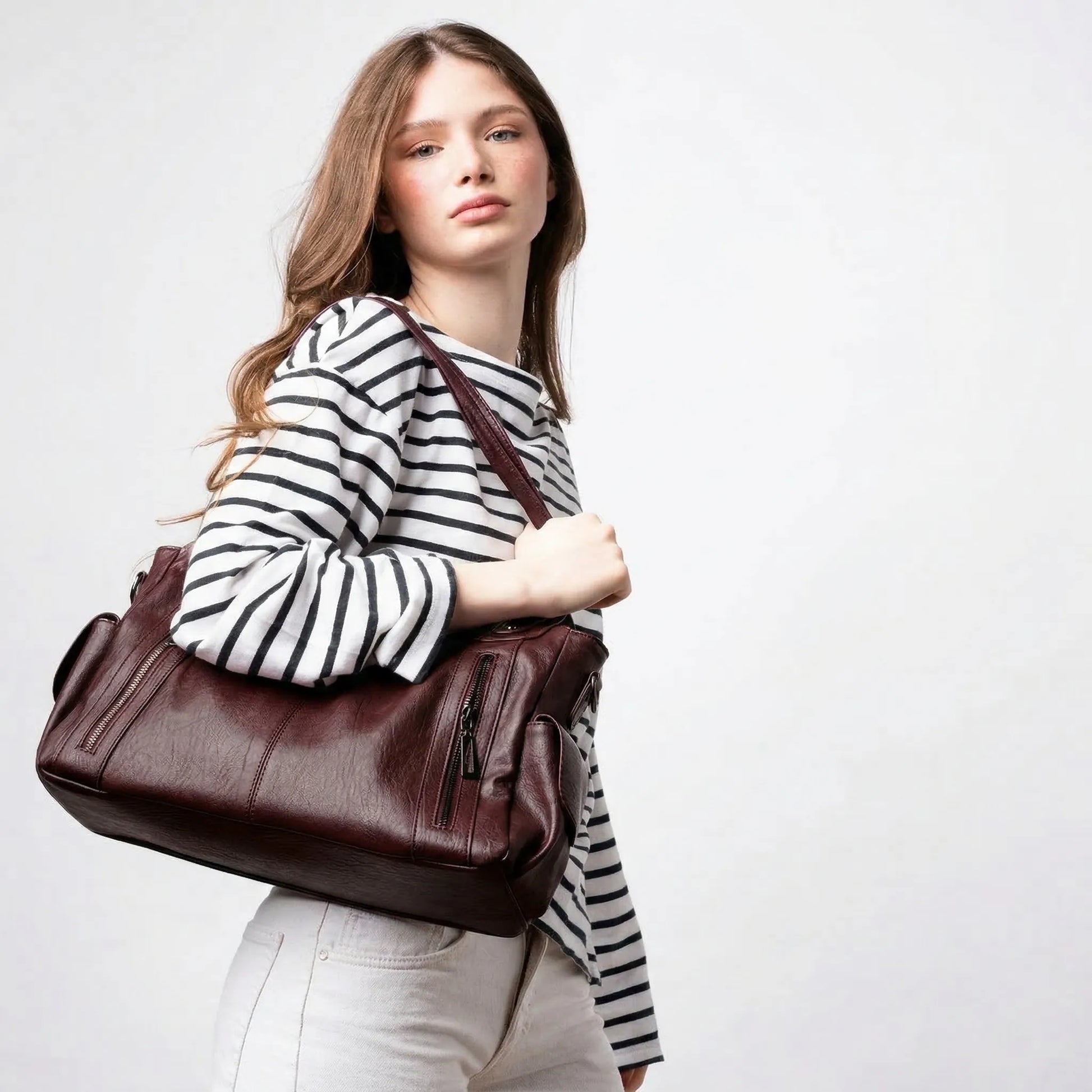 Woman holding Malibu Bag wine red leather hobo bag casual outfit
