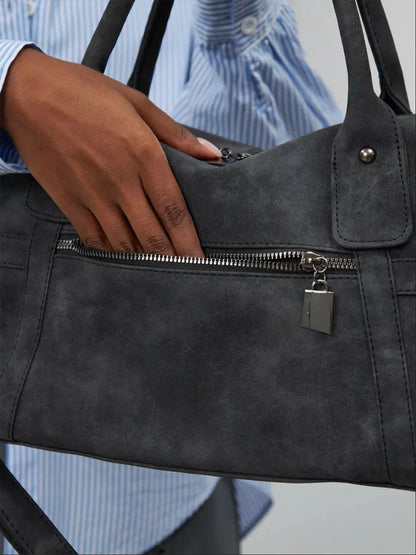 LA Bag anthracite black leather held by hand close up
